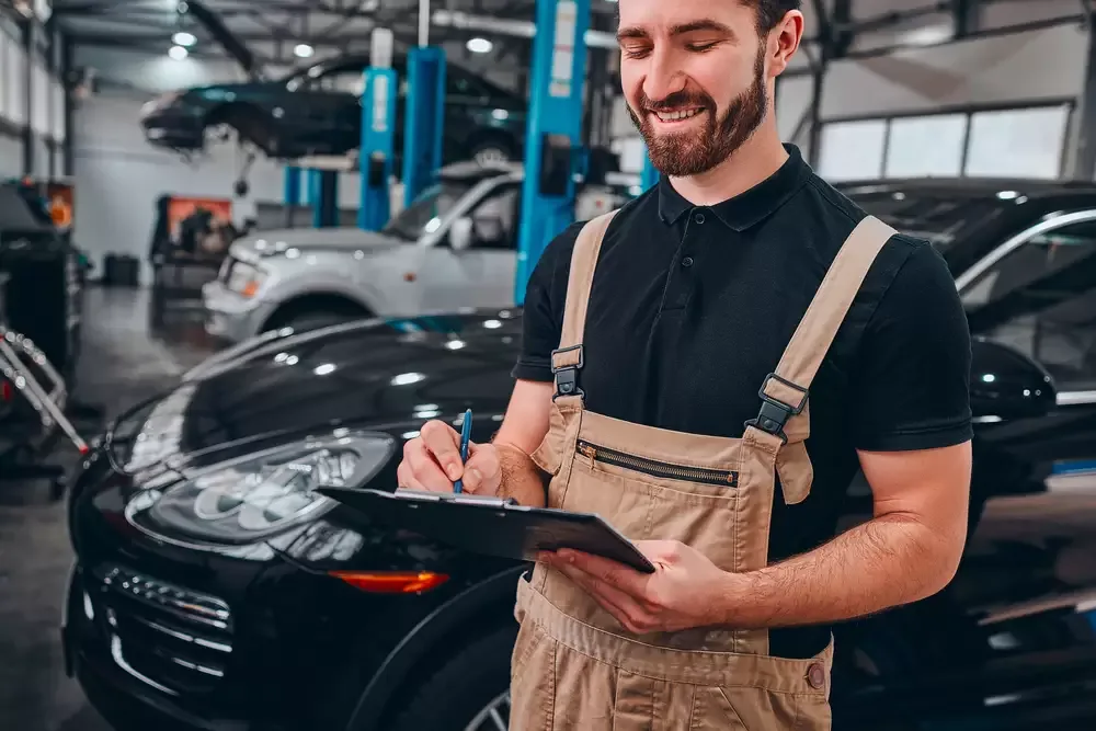 Mecanic completând o fișă de lucru într-un service auto
