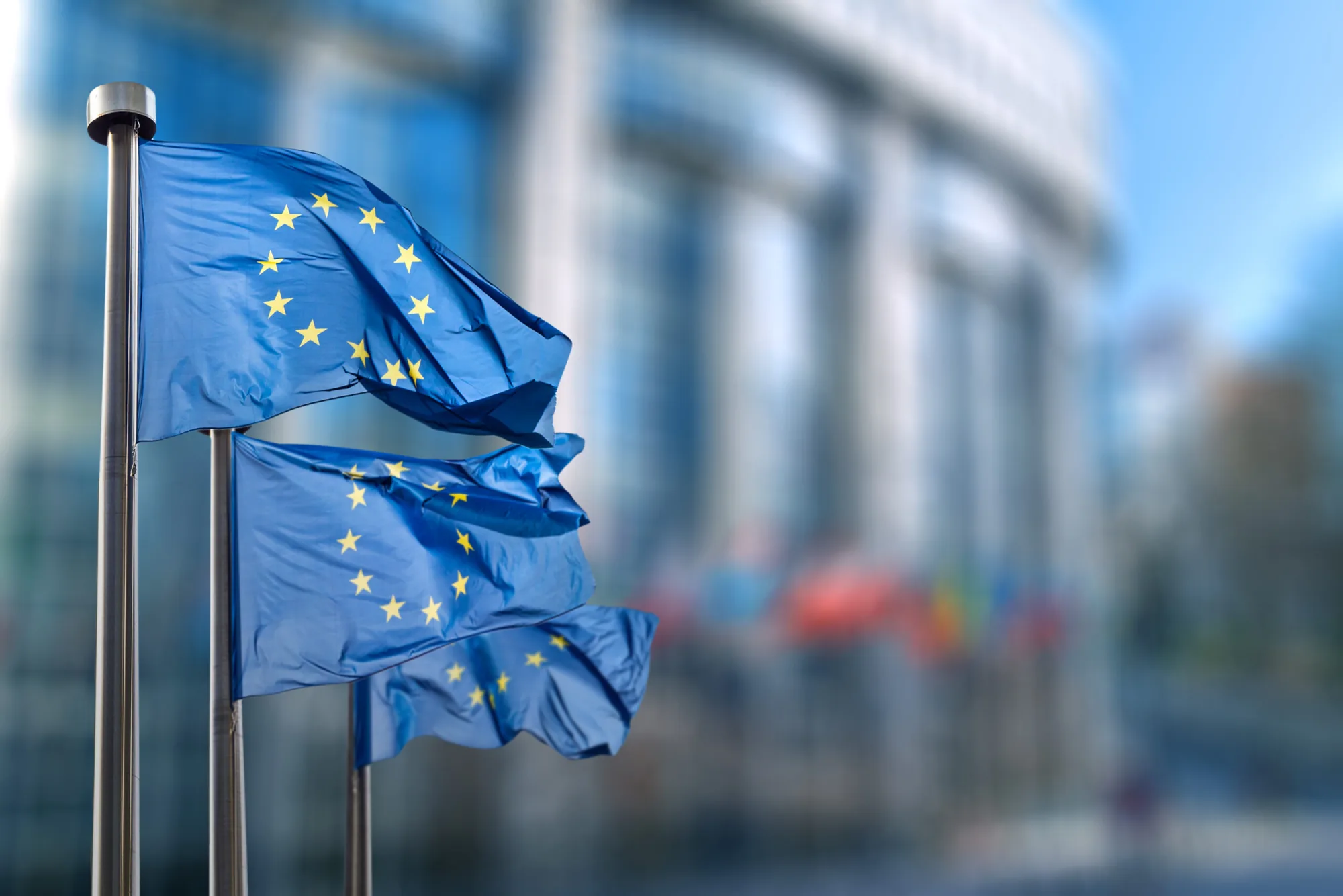Trei drapele ale Uniunii Europene în fața clădirii Parlamentului European