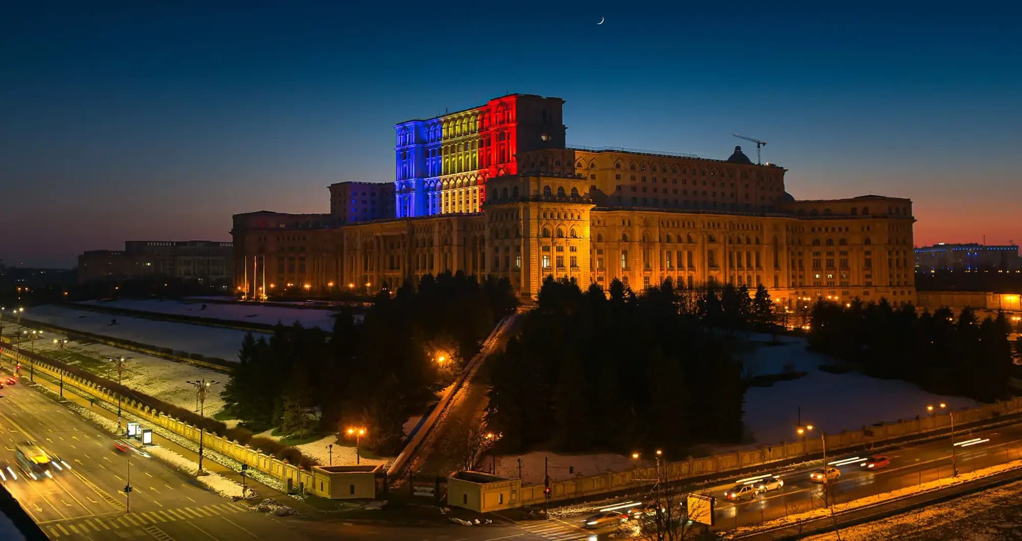 Palatul Parlamentului din București iluminat în culorile drapelului României